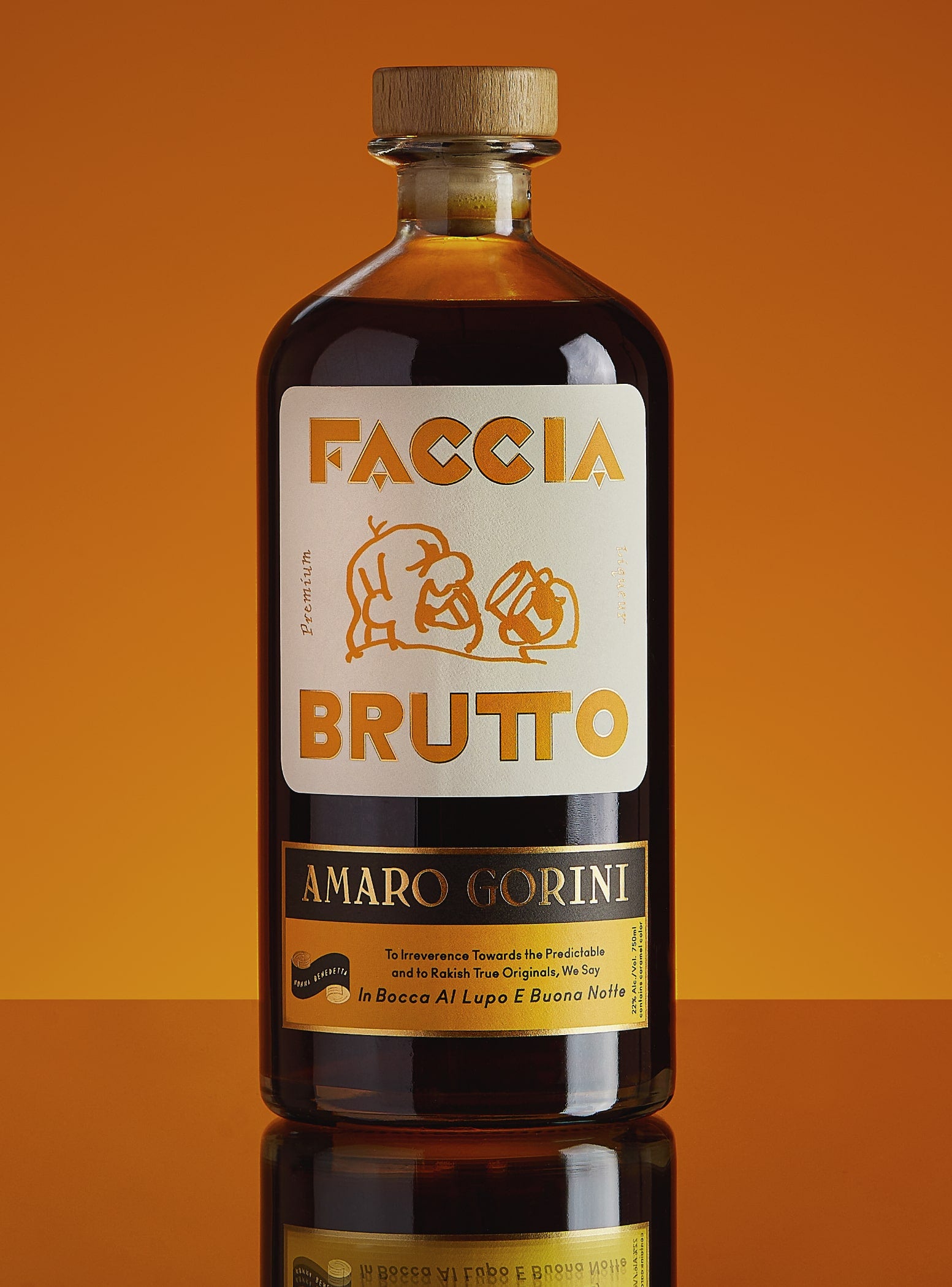 Bottle of Faccia Brutto on its side, orange with missing section of peel, and cocktail in tall coupe glass with dark cherry garnish