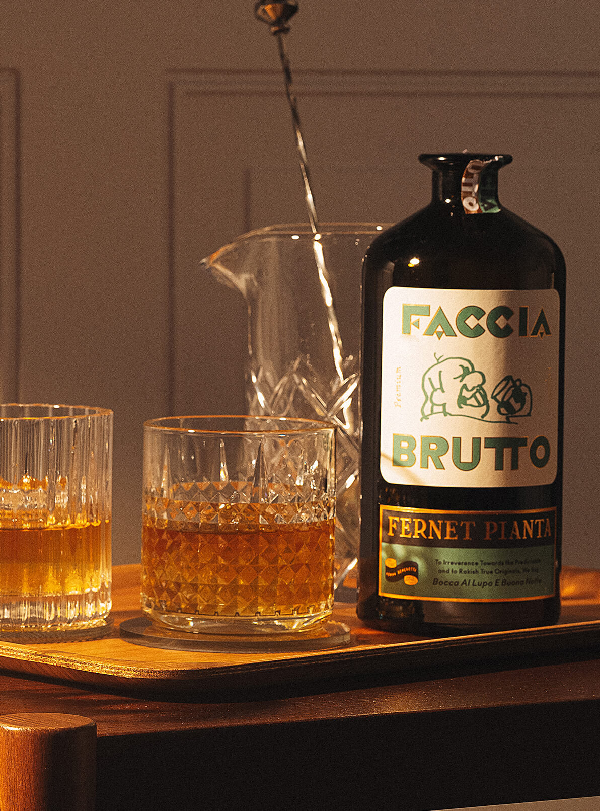 Bar cart with two cocktails, stirrer and bottle of Faccia Brutto Fernet Pianta